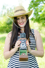 Beautiful young woman with an old camera