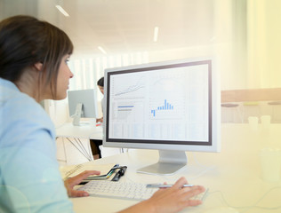 Obraz na płótnie Canvas Back view of office worker in front of desktop