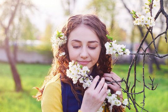 young beautiful woman in the blossoming spring garden