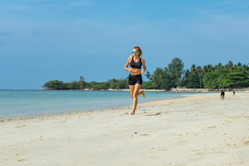 Fototapeta na wymiar Young woman running on the beach 