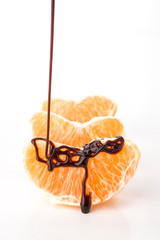 chocolate jet falling on orange fruit