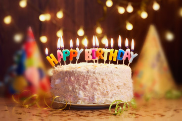 Birthday cake with candles, bright lights bokeh. - Powered by Adobe