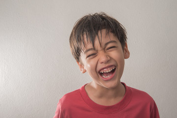 Little boy mix rate laughing with happy face on gray background