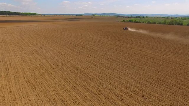 Aerial view of ploughed field with tractor. Industry and Agriculture in Czech Republic, European Union.