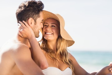 Fototapeta premium Young couple sitting on sand