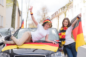 Fototapeta na wymiar zufriedene deutsche fans an einem auto