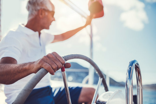 Senior man at the wheel of a yacht