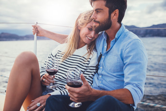 Romantic couple with red wine on yacht