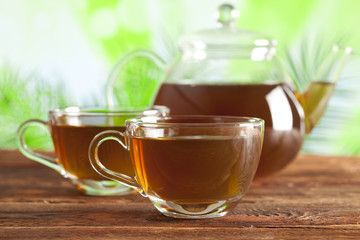 Cup of tea and teapot on nature background