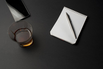 cognac notepad  pen on a black table