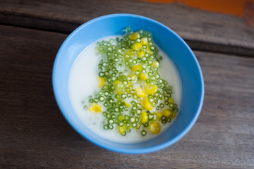 Tapioca pudding or Sakoo (Thai dessert) with coconut milk on wood table (Selective focus)