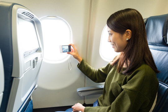 Woman taking photo on airplane