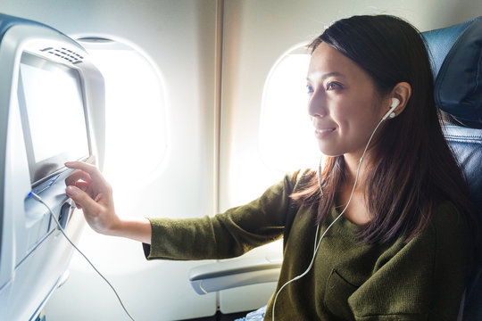 Woman watching movie on entertainment on plane