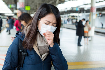 Woman wearing face mask at train station