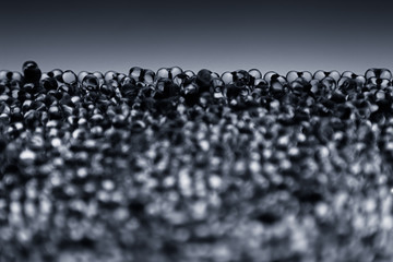 Minimalist abstract dark background with transparent glass particles. The texture.