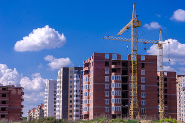 Fototapeta na wymiar Construction of a brick high-rise building with a crane