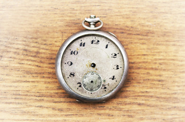 Old pocket watch on a wooden background