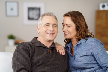 lachendes paar zu hause auf dem sofa