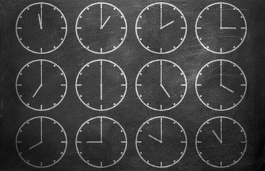 Clock from chalk on black chalkboard background texture