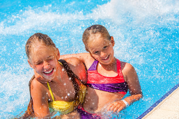 Two children in water at aquapark . Children hugging. Summer holiday.  Outdoor.