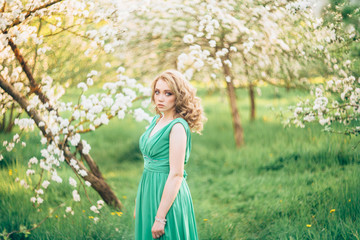 Fototapeta na wymiar Beautiful happy young woman in spring blossoming garden