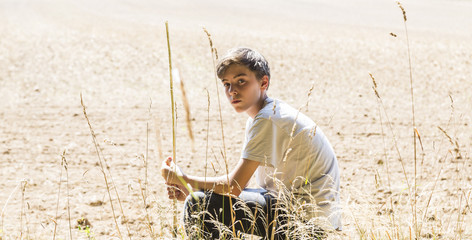 lonely teenage boy sitting in the sun