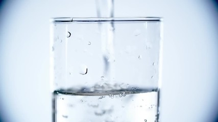 Close up of pouring sparkling mineral water, it splashing and overflowing from it
