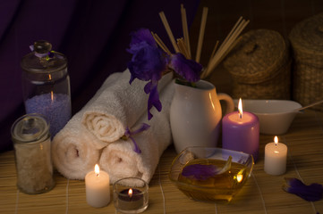 Close-up. Spa still life. Sea salt bath, massage oil, candles, flowers and towels. Iris flowers.
