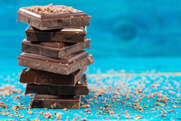 Dark chocolate stack on blue wooden background