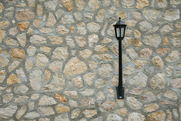 Vintage black lantern on a stone wall