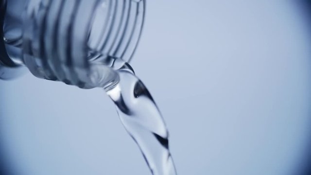 Close up of pouring clean drinking water from the plastic bottle