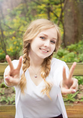 Attractive blonde girl shows blurred peace signs and smiling