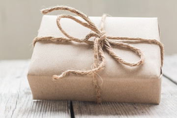 Vintage gift box brown paper wrapped with rope on wood backgroun
