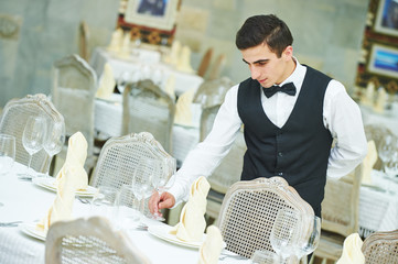 waiter man serving banquet table at restaurant