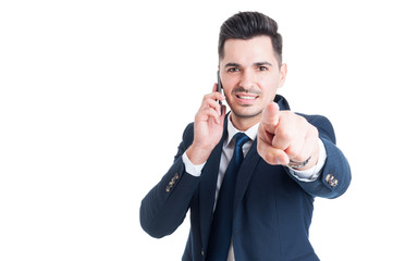 Handsome young businessman talking on smartphone and pointing  f