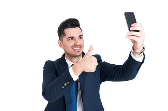 Happy businessman making a selfie and showing thumb up