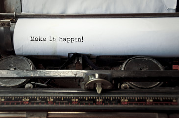 close up image of typewriter with paper sheet and the phrase: make it happen. copy space for your text. retro filtered 