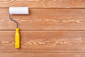 Paint roller on a wooden background 