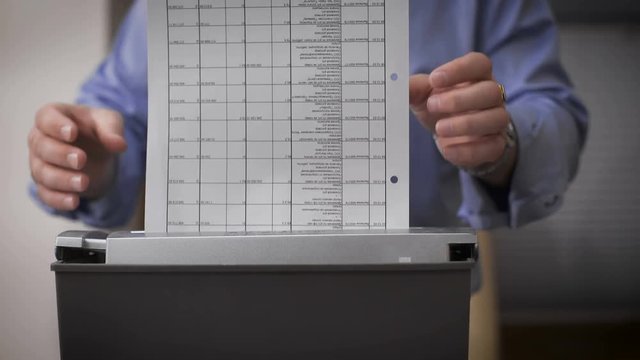 Close-up of male hands destroy documents. Female hands serving reports for destruction.