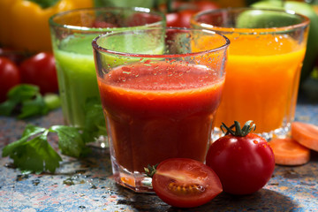 assortment of delicious vegetable juices on a blue background