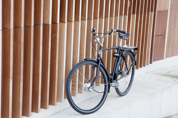 Black bicycle supported on a modern wall