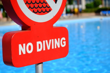 Red no diving warning sign at the poolside