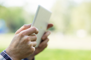 Man's hand using digital tablet computer on green background