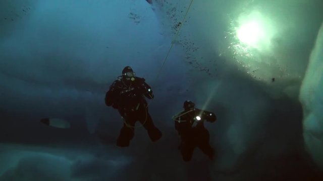 Unique extreme underwater shooting scuba dive beneath ice at geographic  North Pole in cold waters. Fantastic views of the lump of ice in water. ICE CAMP BARNEO, NORTH POLE, ARCTIC - APRIL 10, 2015