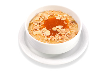 Oatmeal porridge in bowl topped with honey and nuts isolated