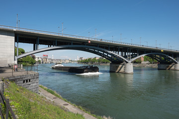 Fototapeta na wymiar Frahtschiff Fährt unter der Brücke im Fluss