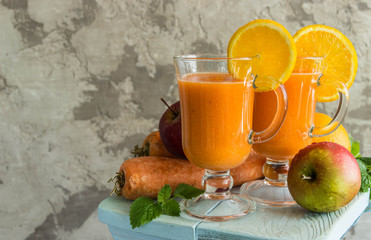 Smoothie made from apple, carrot, orange with a slice of orange, mint, selective focus