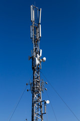telecommunication towers with antennas on blue sky