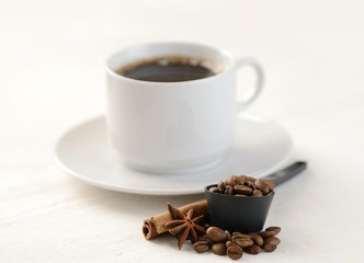 Coffee beans with cup of coffee on background