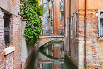 Beautiful narrow canal with silky water in Venice, Italy